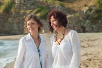 Due donne in piedi sulla spiaggia — Foto stock