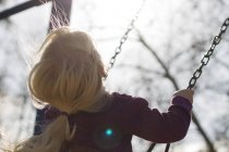 Girl sitting on a swing — Stock Photo