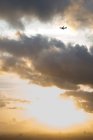 Avión volando en el paisaje nublado - foto de stock
