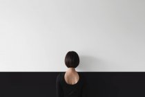 Donna in piedi parete di fronte — Foto stock