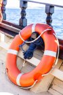 Boya de vida naranja en barco - foto de stock