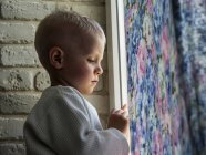 Junge schaut zum Fenster — Stockfoto