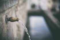 Agua saliendo del grifo por canal de agua - foto de stock