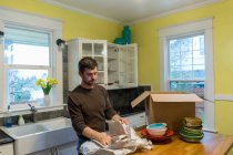 Hombre empacando platos para el movimiento de la casa - foto de stock