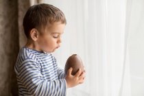 Junge isst Schokolade-Osterei — Stockfoto