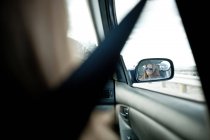 Mulher no espelho da asa do carro — Fotografia de Stock