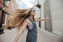 Женщина кружится на городской улице — стоковое фото