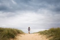 Fille courir à travers les dunes de sable — Photo de stock