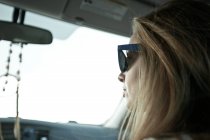 Жінка в сонцезахисних окулярах водіння автомобіля — стокове фото