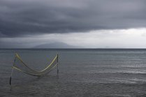 Волейбольная сетка в океане — стоковое фото