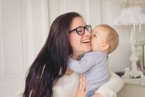 Щаслива мати обіймає маленького сина вдома — стокове фото