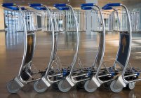 Chariots d'aéroport pour bagages debout en rangée, gros plan — Photo de stock