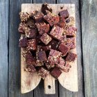 Piazze di torta al cioccolato su tagliere di legno — Foto stock