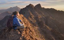 Estados Unidos, Arizona, hombre meditando en la cima de las montañas Mohawk - foto de stock