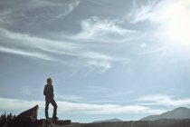 Человек, стоящий на скале и смотрящий на горы, США, Колорадо, округ Эль-Пасо, Пикс-Пик — стоковое фото