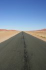 Vue panoramique sur la route vide dans le désert de Namibie — Photo de stock