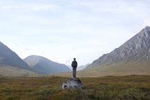 Man standing on rock and looking at view, Highlands, Escócia, Reino Unido — Fotografia de Stock