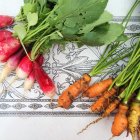 Freshly picked radishes and carrots on ceramic table top — Stock Photo