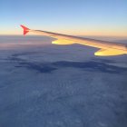 Aile d'avion et coucher de soleil au-dessus des nuages — Photo de stock
