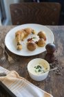 Brathähnchen und Kartoffeln mit Sauce über rustikalem Holztisch — Stockfoto