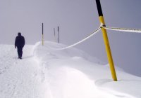 Uomo che cammina nella neve sul pendio con pali — Foto stock