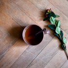 Une tasse de thé et une fleur par terre — Photo de stock