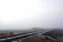 Visão mística das vias férreas que desaparecem no nevoeiro — Fotografia de Stock
