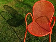 Primo piano della sedia arancione in erba verde — Foto stock