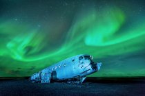 Northern lights over plane wreckage, Iceland — Stock Photo
