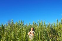Woman standing in a field with head back and hands on chest — Stock Photo