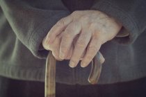 Close-up of male hands holding walking stick — Stock Photo