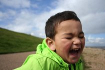 Крупный план портрета очаровательного маленького мальчика, смеющегося — стоковое фото