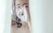 Spain, Malaga, Girl showering and making soap bubbles — Stock Photo