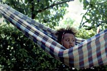 Portrait of cute little girl in hammock during summer day — Stock Photo