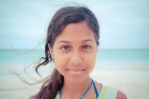 Крупный план портрета молодой красивой девушки на пляже, смотрящей в камеру — стоковое фото