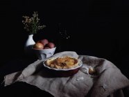 Baked quiche in rustic installation against black background — Stock Photo