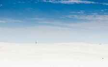 Vista à distância de Boy standing in desert, Green Head, western Australia, Australia — Fotografia de Stock
