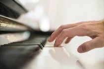 Primo piano di mano maschile che suona il pianoforte — Foto stock