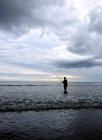 Mann angelt im Ozean unter bewölktem Himmel — Stockfoto