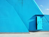 Ponte blu a bordo della nave con porta in metallo e cielo blu — Foto stock