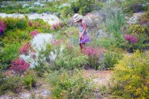 Chica caminando a través de flores silvestres en la naturaleza - foto de stock