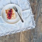 Кусочек ревеня и безе торт на тарелке на белой салфетке — стоковое фото