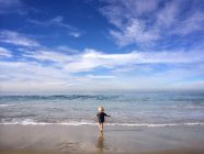 Blonder kleiner Junge läuft am Strand — Stockfoto