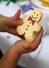 Обрізане зображення дитини, що тримає імбирне печиво, крупним планом — стокове фото