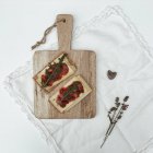 Crispbread with cheese and fig jam on chopping board — Stock Photo