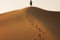 Veduta posteriore di Donna in piedi su una duna di sabbia nel deserto, Dubai, Emirati Arabi Uniti — Foto stock