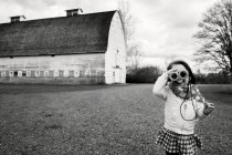 Entzückendes kleines Mädchen, das durch ein Fernglas schaut — Stockfoto