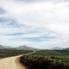 Vue panoramique de la route sinueuse sous le ciel avec de beaux nuages — Photo de stock