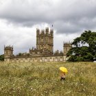 Frau mit gelbem Regenschirm auf Wiese, Highclere Castle, hampshire, uk — Stockfoto