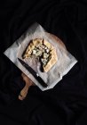 Fennel and mozzarella galette on parchment on wooden board — Stock Photo